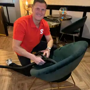 Diepe reiniging van tapijt door professionele schoonmaker met stofzuiger.