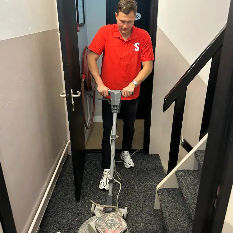 Stofzuigerreiniger in gebruik door medewerker bij Snelle Reinigers, professionele schoonmaakdienst.